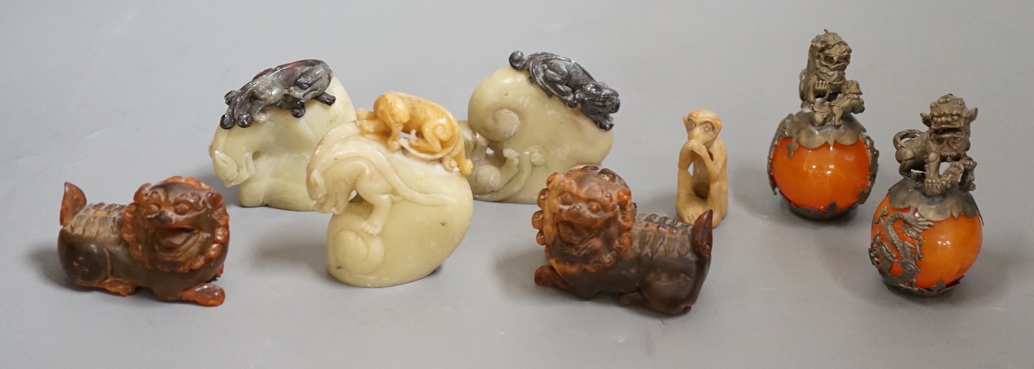 Two carved horn Buddhistic lions, four soapstone carvings and a pair of Chinese nickel and amber-glass ornaments, horn lions 5cm wide